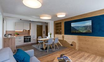 A modern apartment with an open living area. The décor is bright and inviting, featuring a dining area and a cozy seating corner.