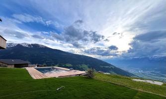 A beautiful view of the mountains with a pool in the foreground. The sky is cloudy and conveys a calm atmosphere.