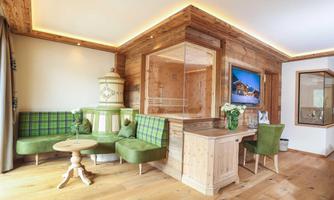 A cozy living space with wooden-paneled walls and a modern seating area. The decor combines traditional and modern elements, perfect for relaxation.
