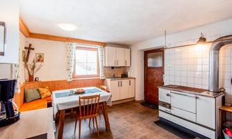 A cozy kitchen with a dining table, chairs, and a large stove.  
Bright walls and charming details create an inviting atmosphere.