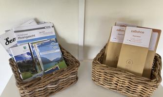 Two baskets with informational materials. On the left are brochures for excursion destinations, on the right are menu cards of a café.