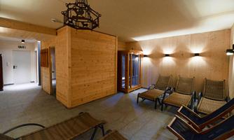 A relaxation area with loungers and wood paneling. The light is soft and creates a relaxed atmosphere.