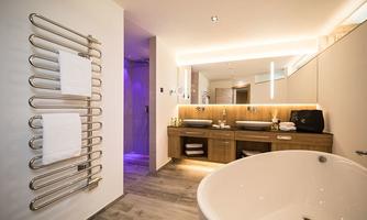 A modern bathroom with a freestanding bathtub and an elegant wash area. The combination of wood and neutral tones creates a relaxing atmosphere.
