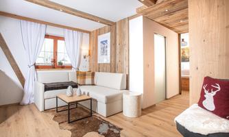 A modern living room with a cozy couch and wood paneling. Bright curtains and a warm color scheme create an inviting atmosphere.