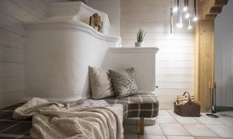 A cozy living area with a bright ambiance. A sofa with cushions and a blanket invites you to relax.