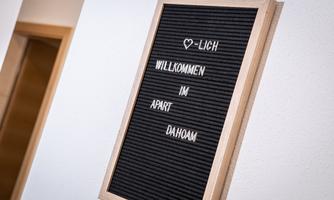 A sign with the inscription "♥-LY WELCOME TO APART DAHOAM". It radiates an inviting atmosphere.