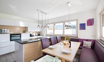 Modern kitchen with a dining area and large windows. Bright space with stylish furniture and a cozy atmosphere.
