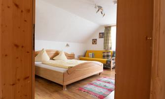 A cozy bedroom with two beds and pillows. The room has a warm ambiance and pleasant decoration.