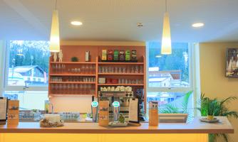 A friendly café area with a well-stocked bar and large windows that offer a view of the mountains. The lighting is bright and inviting.