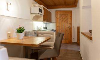A cozy kitchen with a dining table, chairs, and a modern design.