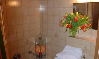 A modern bathroom with a bathtub and a sink. Fresh flowers in a vase create a pleasant atmosphere.