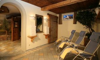 A stylish relaxation room with lounge chairs and a warm ambiance. Soft lighting and natural elements create an inviting atmosphere.