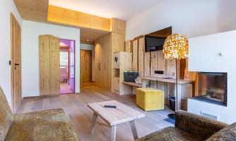 A cozy living room with wood paneling and modern furniture. The room has large windows and a warm, inviting atmosphere.