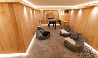 A modern room with wooden paneling and soft lighting. Cozy bean bags and a table create an inviting atmosphere.