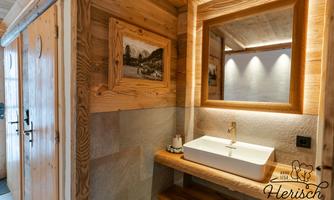 A modern bathroom with wooden cladding and an elegant sink. The warm colors and soft lighting create an inviting atmosphere.