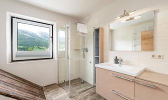 A modern bathroom with a shower and a large window. The bright colors and clean design create an inviting atmosphere.