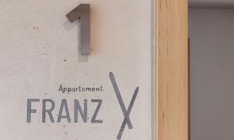 A sign with the number one on the wall. Below it, it says "Apartment FRANZ".