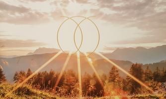 A beautiful sunrise over the mountains. Rays break through the sky and fall on the green meadows.