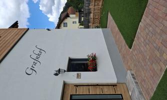 A modern house with an appealing entrance. The garden is well-maintained and the sky is blue with some clouds.