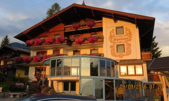 A picturesque house with colorful flower balconies. The evening sun bathes the facade in a warm light.
