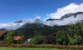 A beautiful mountain view with gentle clouds and green grass. The landscape is calm and invites relaxation.