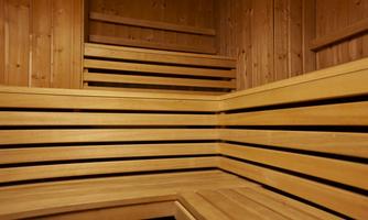 A cozy sauna with wooden benches and walls. The room radiates warmth and relaxation.