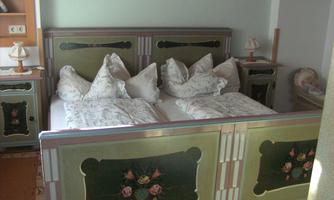 A cozy bedroom with a double bed and a beautiful floral design. Bedside tables and lamps complement the inviting atmosphere.