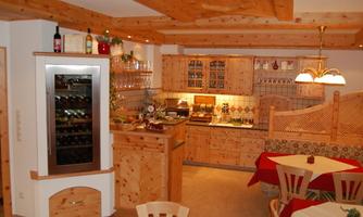 A cozy interior with wooden furniture and warm colors. The room is decorated with a large beverage fridge and an inviting table.