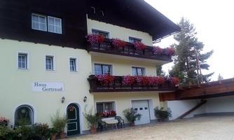 A charming house with flower balconies and a rustic appearance. Surrounded by trees and a spacious driveway.
