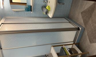 A modern bathroom with a shower and a sink. Towels and toiletries are neatly arranged.