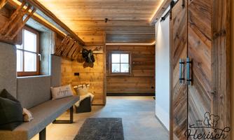 A cozy interior with wood paneling and a modern rustic design. The atmosphere is warm and inviting, perfect for relaxing.
