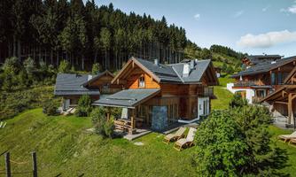 A modern wooden holiday apartment in a green mountain landscape. Surrounded by trees and meadows, it offers a peaceful retreat.