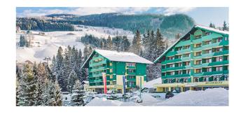 A colorful hotel amidst a snowy landscape. Surrounded by tall, snow-covered trees and mountains, it offers a picturesque winter setting.