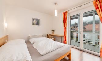 A well-equipped bedroom with a double bed and two large pillows. The window front offers a nice view outside and lets in plenty of daylight.