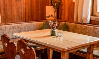 A cozy table in a wood-paneled setting. The seating area is adorned with plants and decorative elements.
