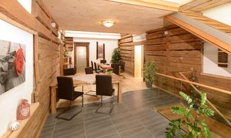 A cozy reception area with wooden paneling and modern furniture. The room is bright and inviting, perfect for relaxed encounters.