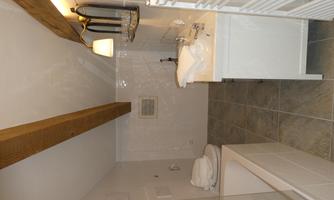 A modern bathroom with a bathtub and a sink. Bright tiles and wooden elements create an inviting atmosphere.