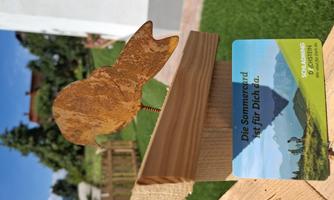 A rusty bird ornament on a wooden platform. Below it is a card with the text "The summer card is here for you."
