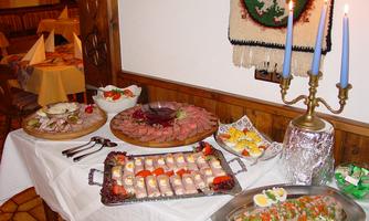 A festively laid table with various meat and fish dishes. Candles and decorative garnishes complete the ambiance.