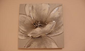 A stylized flower in shades of gray and white is depicted on a canvas. The image conveys a calm and elegant atmosphere.