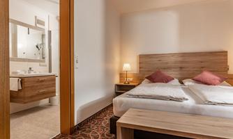 A cozy room with a double bed and a modern bathroom. The room is bright and inviting, ideal for a relaxing stay.