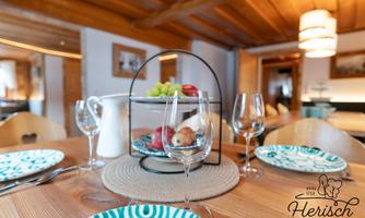 A beautifully set table with colorful dishes and a fruit basket in the center. The ambiance is cozy and inviting.