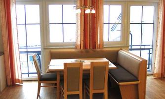 Unanimous kitchen with a table and chairs. Large windows let in plenty of light.