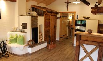 A cozy living space with wooden accents and an open fireplace. The decor is comfortable and inviting.