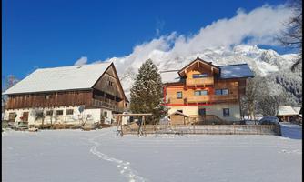 A picturesque winter village with snow-covered houses. The sun is shining under a clear blue sky.