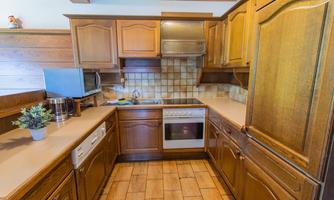 A cozy kitchen with wooden furniture and modern appliances. The space feels bright and inviting.