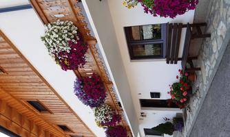 A charming, bright house with a wooden balcony. Colorful flower boxes adorn the façade and invite you to linger.
