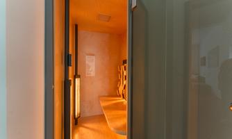 A modern, bright room with wooden paneling and warm lighting. There is a seating area and an informative display on the wall.
