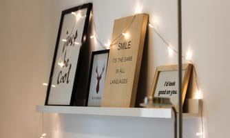 A modern shelf with several picture frames and small lights. The frames contain inspiring quotes and pictures of animals.