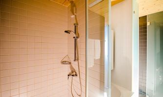 A modern shower cubicle with bright tiles and a clear partition. The design is simple and functional, ideal for a bathroom.